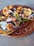 Delicious dish of Sopes and seafood tostadas that are a fried tortilla with beans, shrimp and octopus on top