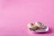 Delicious donuts on dish, pink shadeless background