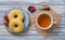 Delicious doughnuts, silver old teaspoon, cup of green chamomile tea