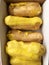 Delicious eclairs with yellow glaze in a box