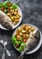 Delicious family lunch table - dorado fish baked with potatoes, lemon and sage on dark background, top view