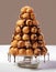 Delicious festive croquembouche with chocolate glaze on a light background.