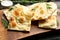 Delicious focaccia bread on wooden board, closeup