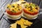 Delicious food appetizer Mexican seven-layer dip salad served with chips close-up. horizontal