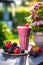 Delicious fresh berries smoothie served outside on a sunny day. Healthy fitness snack.