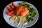 Delicious fresh food plate with seafood, cheese and salat. Salmon topped with fish caviar, meal on white plate on black background