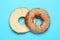 Delicious fresh halved bagel on blue background, flat lay