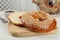 Delicious fresh halved bagel on white wooden table, closeup