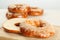 Delicious fresh halved bagel on wooden board, closeup