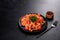 Delicious fresh paste with tomato sauce with spices and herbs on a dark background