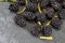 Delicious fresh and ripe blackberries and reddish garnet. With drops of water. On textured background in black color.With yellow l