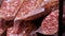 Delicious fresh salami sausages on the meat butcher market counter close up