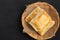 Delicious fresh square butter pie bread in basket on a black background.