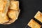 Delicious fresh square butter pie bread in basket on a black background.