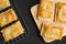 Delicious fresh square butter pie bread on wooden plate on a black background.