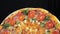 Delicious freshly baked Italian pizza, close-up, which is spinning on a rotating platform