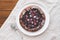 Delicious freshly baked vegan almond berry galette on white rustic tablecloth background.