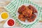 Delicious fried chicken thigh on white plate on table cloth