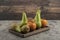 Delicious fuyu persimmons and ripe pears on wooden plate