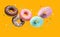 Delicious glazed donuts Falling on orange background.