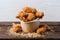 Delicious golden fried chicken in paper cup on wooden surface Mouthwatering treat