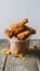 Delicious golden fried chicken in paper cup on wooden surface Mouthwatering treat