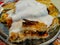 Delicious good looking served Bosnian borek pie with meat and topped with cream served on a plate, a delicious traditional meal on