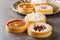 Delicious gourmet sweets tartlets for the holiday with meringue and lemon curd, raspberry curd, nuts and chocolate close-up.