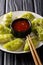 Delicious green dumplings gyoza with matcha with spicy chili sauce and microgreen close-up. vertical