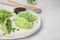 Delicious green dumplings (gyozas) and soy sauce on tiled table, closeup. Space for text