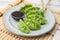 Delicious green dumplings (gyozas) and soy sauce on white table, closeup