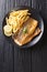 Delicious grilled sea bass filet served with french fries close-up on a plate. Vertical top view