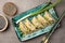 Delicious gyoza (asian dumplings) served on gray table, flat lay