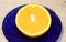 Delicious half orange on blue plate