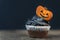 Delicious halloween party black cupcake with gingerbread pumpkins on black background. Copy space. Close up