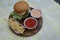 Delicious hamburgers and potato chips accompanied by warm tomato sauce.