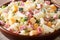 Delicious Hawaiian salad with pasta, ham, pineapple, onion, cheddar cheese and mayonnaise close-up. horizontal