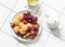 Delicious healthy dessert - fresh ripe fruits and berries strawberries, apricots, cherries and green tea on a light background,