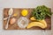 Delicious and healthy green smoothie ingredients on a wooden cutting board before mixing everything together. Bananas, kale, lemon