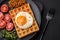 Delicious hearty breakfast consisting of a fried egg, Belgian waffle