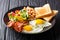 Delicious and hearty meal: two fried eggs with bacon, beans, toa