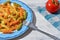 Delicious homemade colorful pasta whit meat sauce and fresh tomato at white wooden background