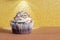 Delicious homemade cupcake on a yellow background of bokeh from sparkles. Holiday food