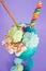 Delicious homemade extreme milkshake with dragees over a milk foam and a rainbow candy on top with a plastic straw in a