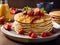 Delicious homemade pancakes with strawberries and syrup on plate