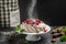 Delicious homemade Pavlova cake with fresh strawberries and whipped cream. chef hands with powder in a freeze motion of a cloud of
