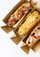 Delicious hot dog grilled in a restaurant, homemade hot dogs wrapped in bacon, with onions and mushrooms, salad. Street food,