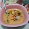 delicious hot and sour Thai soup that have prawn, mushroom, cuttle fish and chicken in a nice pink plate for dinner