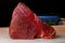 Delicious huge raw yellowfin tuna fish fillet on cutting counter. Black background