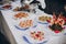 Delicious italian appetizers on table at wedding reception outdoors. Caviar, seafood, canapes, champagne, fruits on table at